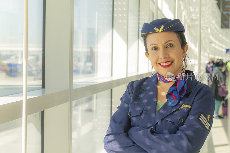 美丽的拉丁空乘人员的肖像，微笑着看着相机，自信的脸和幸福的机场航站楼。欢迎所有客户或乘客乘坐飞机。旅行的概念。