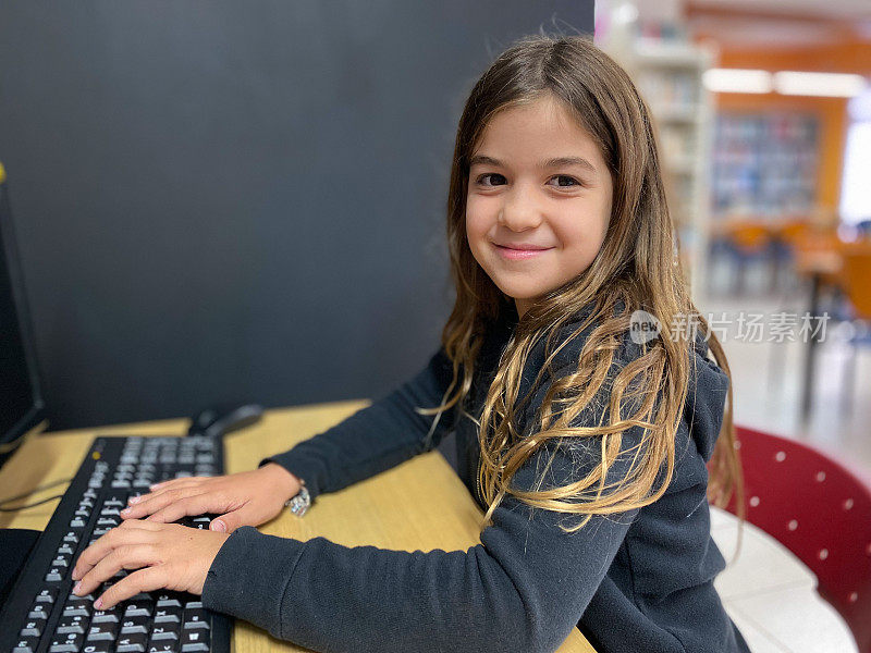 女孩微笑着坐在电脑前上课