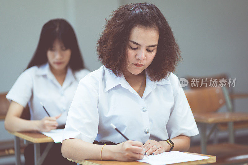 亚洲女大学生在教室里做笔记