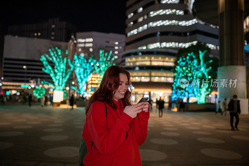 年轻的女游客在夜间拍照