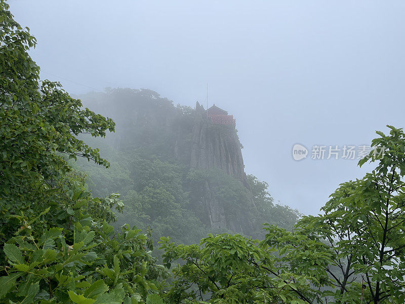 云雾笼罩着悬崖上的小佛寺