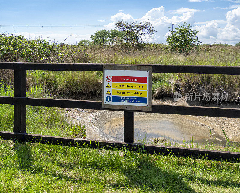 在沼泽地设置有警告标志的安全屏障