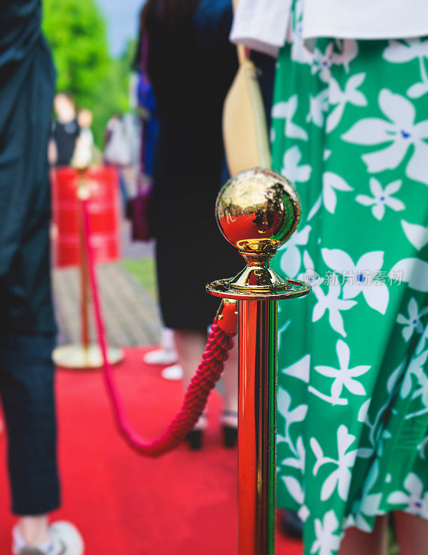 豪华派对入口系着绳索和金色护栏的红地毯，影院首映电影节活动颁奖盛典，贵客到场，户外装饰元素，夏日