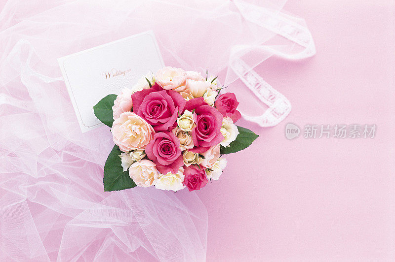 一束粉色和白色的玫瑰和一张礼品卡