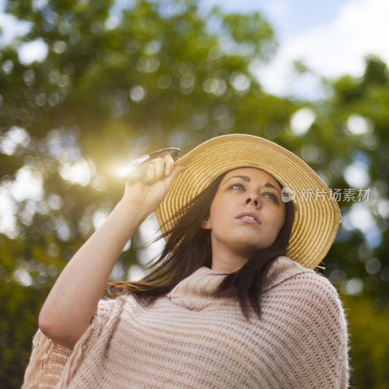 女孩戴着草帽在户外。