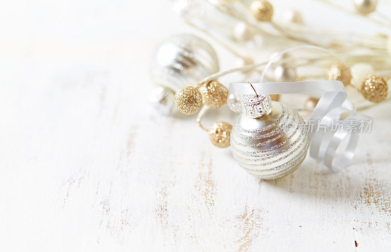 白色木质背景上的银色和金色圣诞装饰品