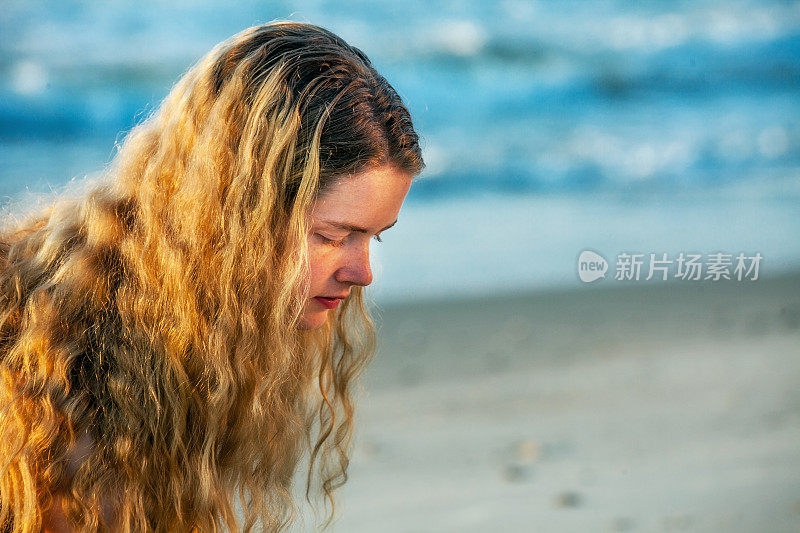 女性少女的特写向下看在海滩设置