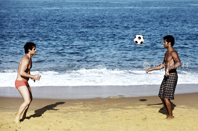 年轻人在沙滩上踢足球