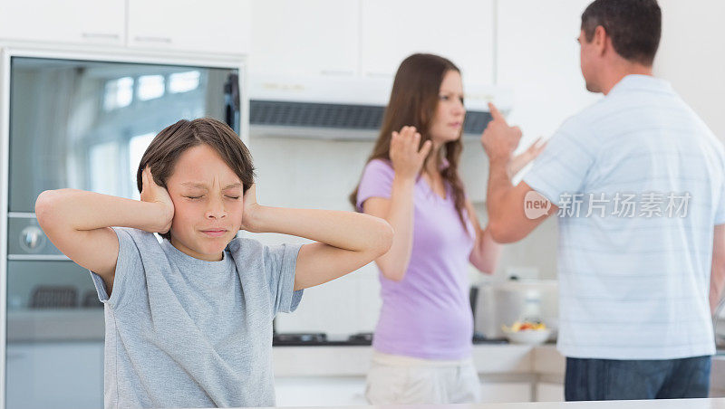 父母在厨房吵架，伤心的男孩捂着耳朵
