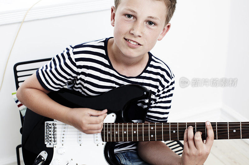 一个十几岁的男孩在玩电吉他