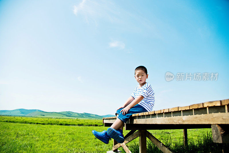 男孩独自坐在大自然的甲板上
