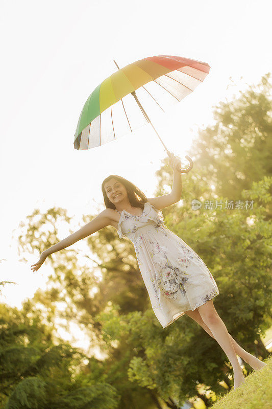 拿着雨伞站在田野里的女人