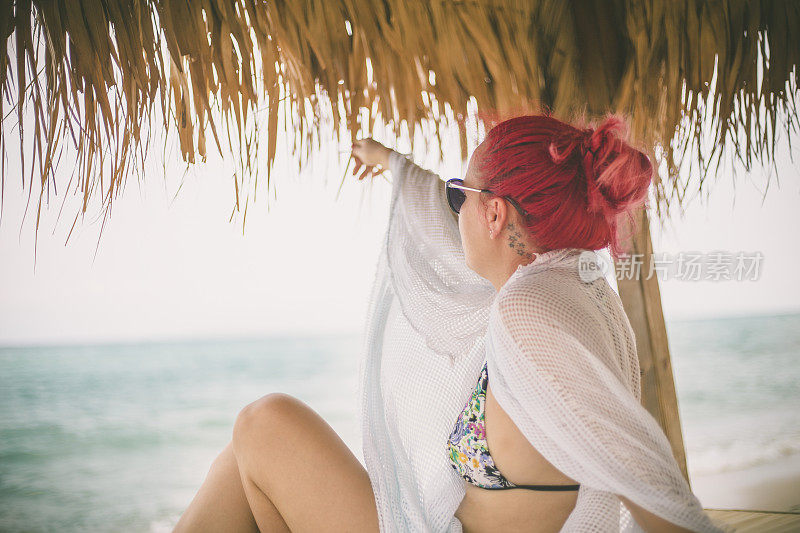 穿着夏装的女人望着天空和大海