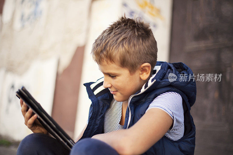 带着数码平板电脑的户外男孩