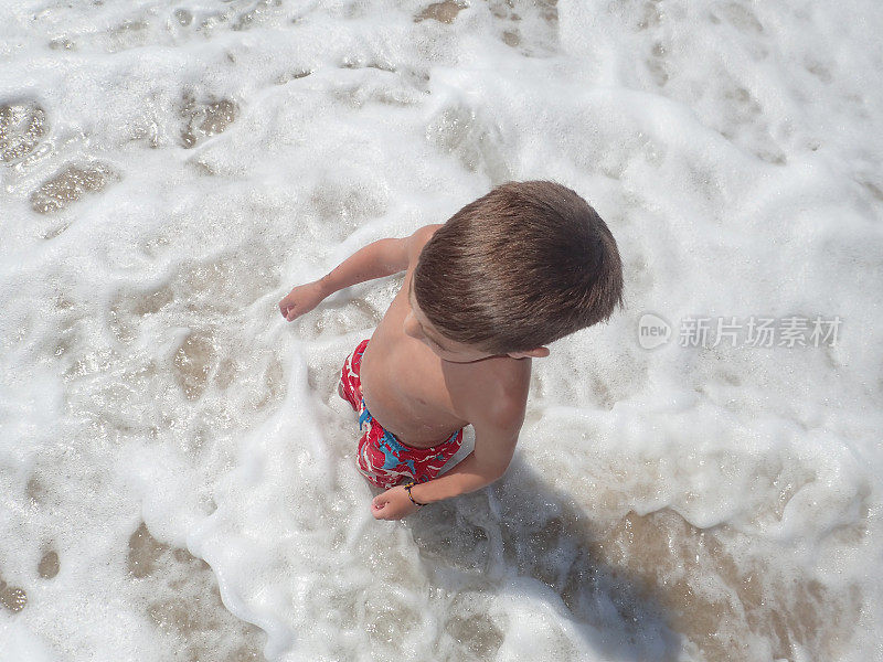 在贝瑟尼海滩冲浪的男孩