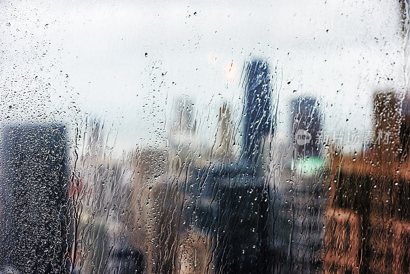 透过带雨条纹的窗户可以看到摩天大楼