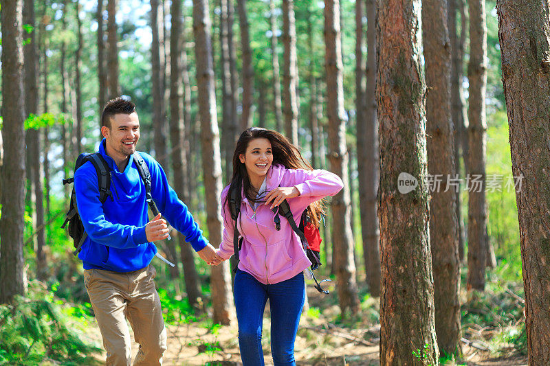 一对快乐的情侣在森林里徒步旅行