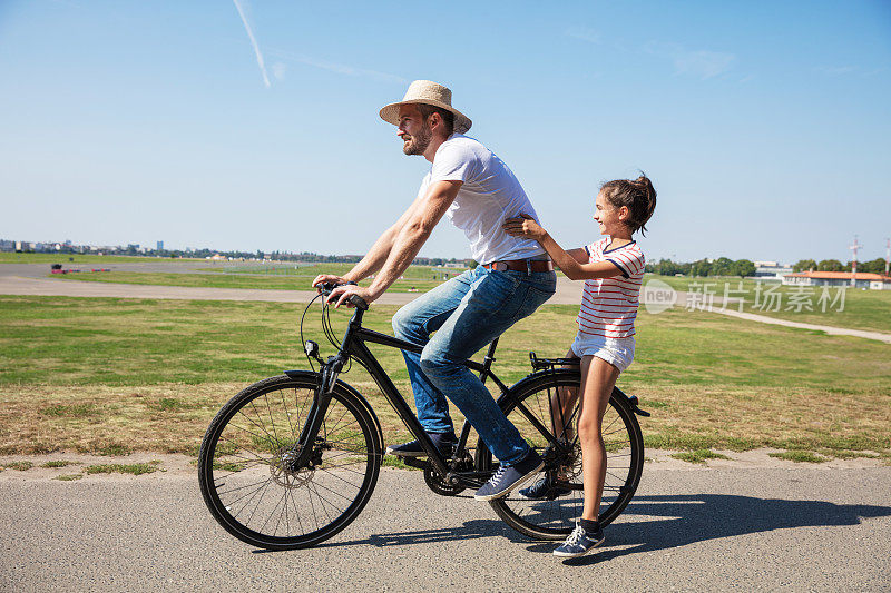 快乐的男人和女儿骑自行车