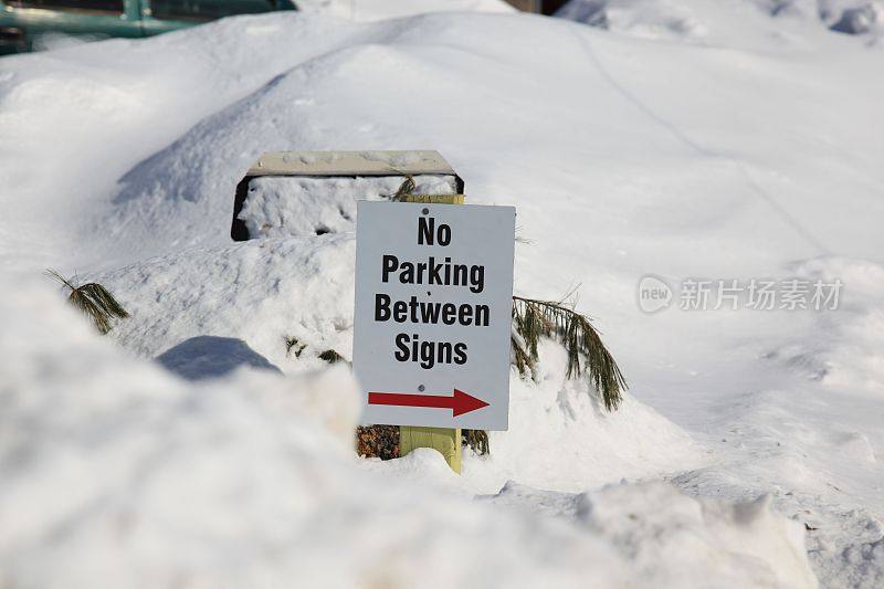 指示牌上写着两个指示牌之间不准停车，但由于雪太多，不可能停车