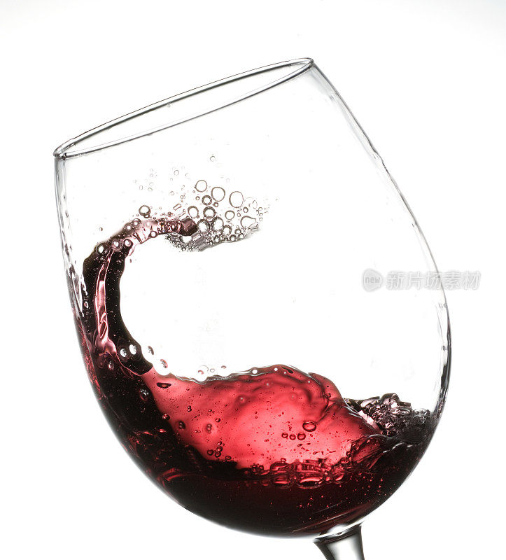 白色背景下，红酒在玻璃杯中摇曳