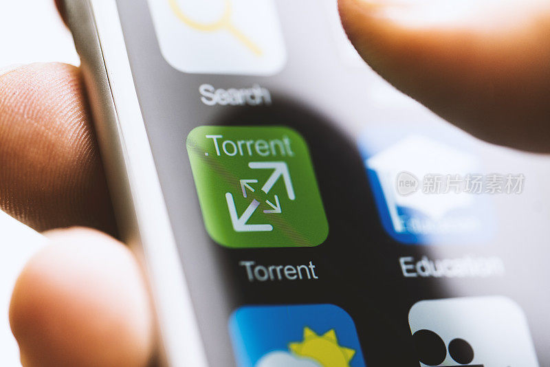 手持手机，触摸torrent应用程序图标