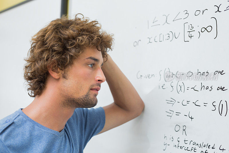严肃的学生站在白板前解数学题