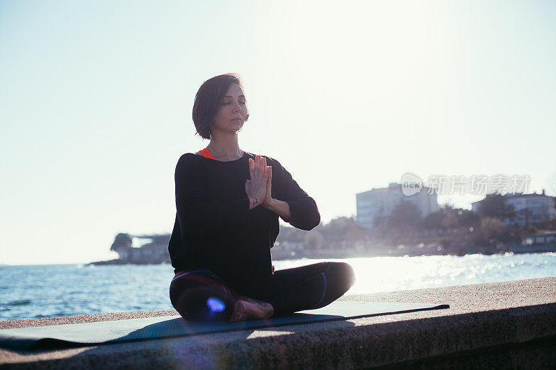 女人瑜伽放松在海边