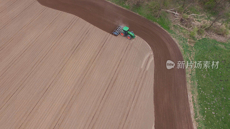 鸟瞰图拖拉机在耕作的田野在春季农业机械