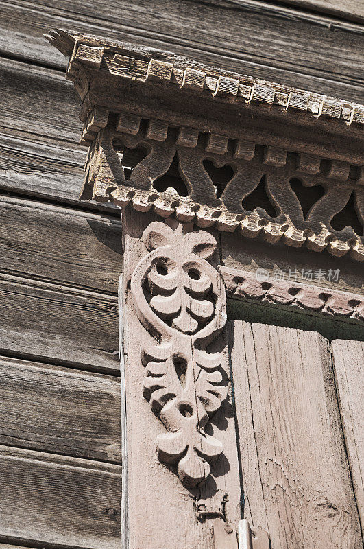 一扇带有装饰元素的俄罗斯老木屋窗户的细节