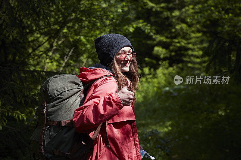 女人搭便车旅行。春天的山