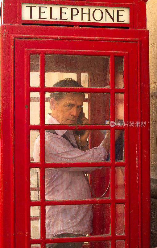 游客(男子)在红色电话亭皱着眉头