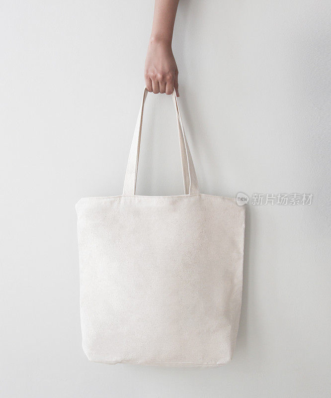 空白帆布手提袋，设计模型与手。手工购物袋。