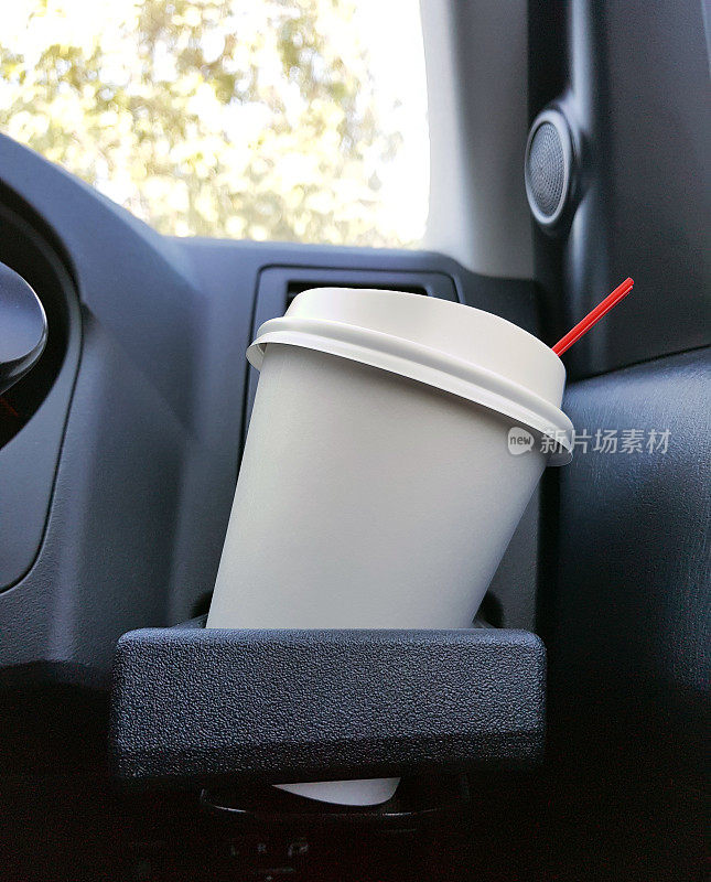 拿走一杯放在汽车前控制台的冰咖啡