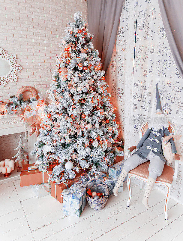 圣诞树和除夕夜。冬天假日的背景。内部细节-镜子雪花，壁炉与灯泡花环，许多礼物和小精灵的礼物。