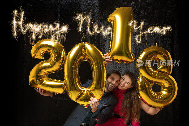 这对情侣正在用气球“2018”和烟花庆祝新年