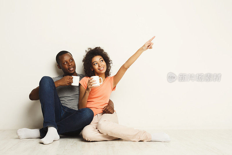 一对非裔美国人夫妇，坐在地板上