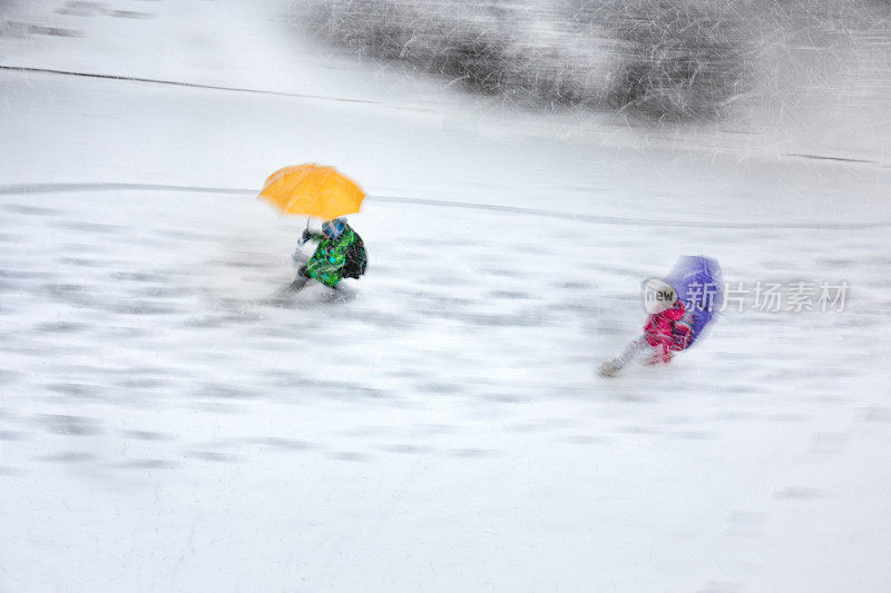 孩子们撑着雨伞在暴风雪中行走