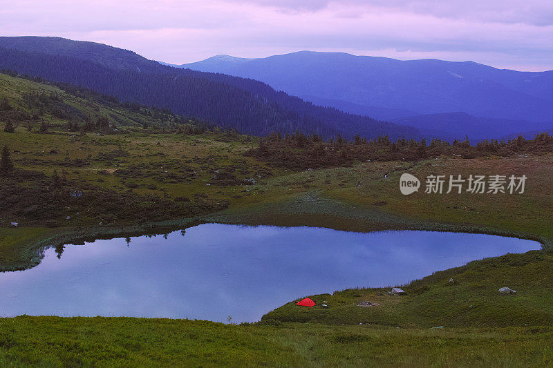 山上湖边的橙色帐篷