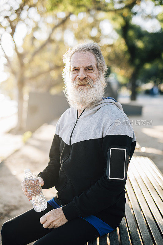 快乐的资深男跑步者和水瓶