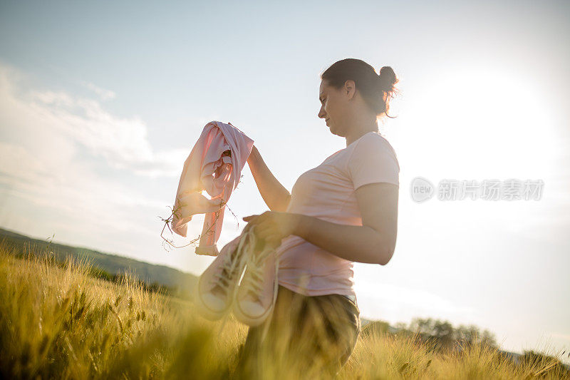 女孩在麦田里看着美丽的夕阳，复古复古的生活方式浪漫的样子