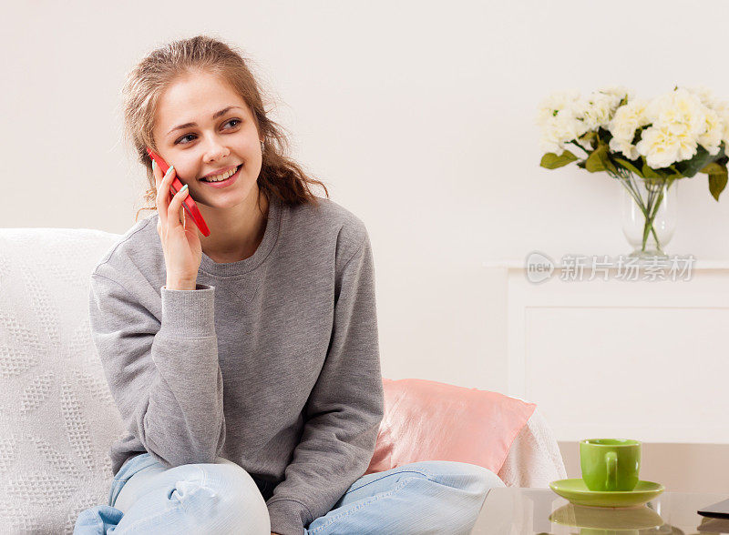 年轻漂亮的女人在家里打电话