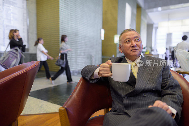 一幅成熟的亚洲商人在咖啡店休息的肖像