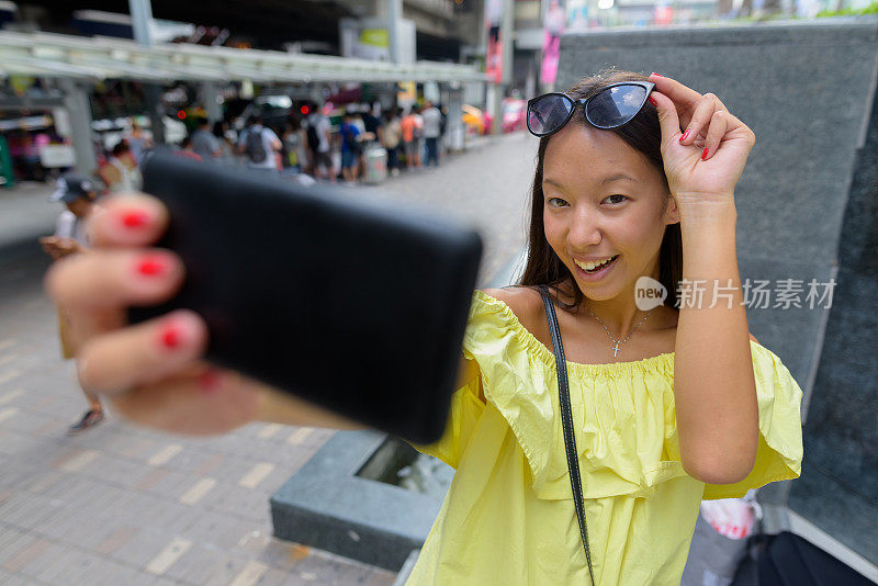 年轻美丽的多民族旅游女人的肖像享受生活在暹罗广场购物中心在泰国曼谷