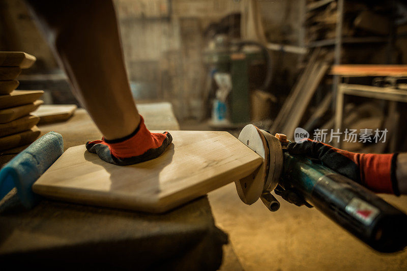 近距离的木匠使用砂光机，而工作在一个车间的一块木头。