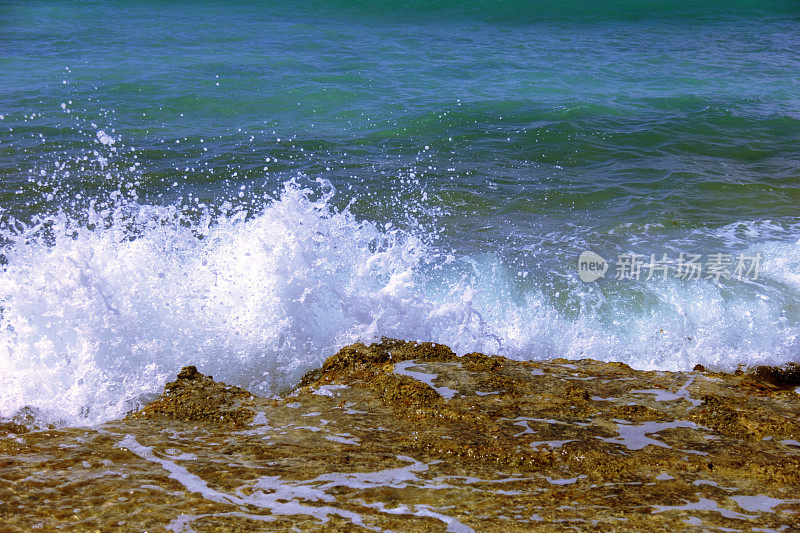 海浪拍打着海滩上的石头。