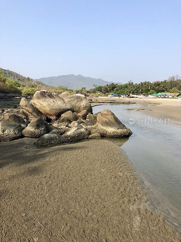 光滑的海滩巨石和岩石的图像，从海浪的海岸水力磨损侵蚀多年来，热带海滩度假天堂的印度度假天然岩石池和海岸流，帕洛伦海滩，果阿，南印度