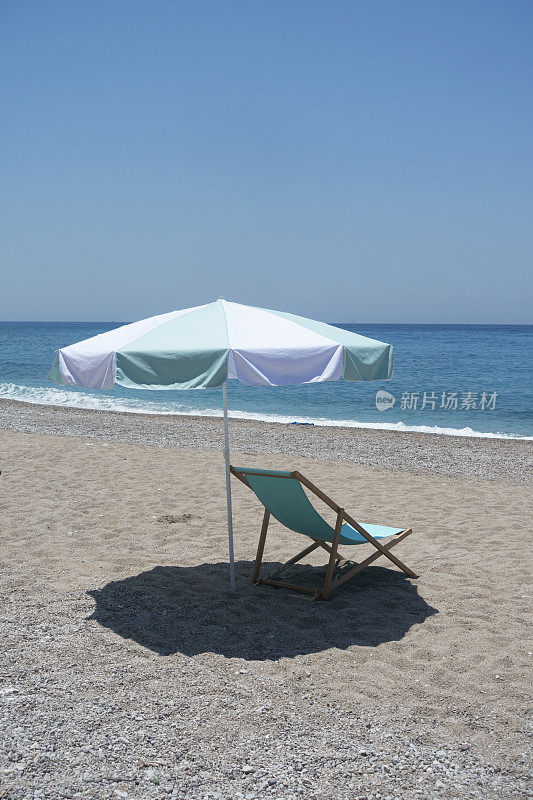 沙滩上带伞的躺椅。