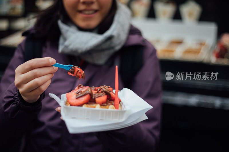 在户外吃比利时华夫饼的女人