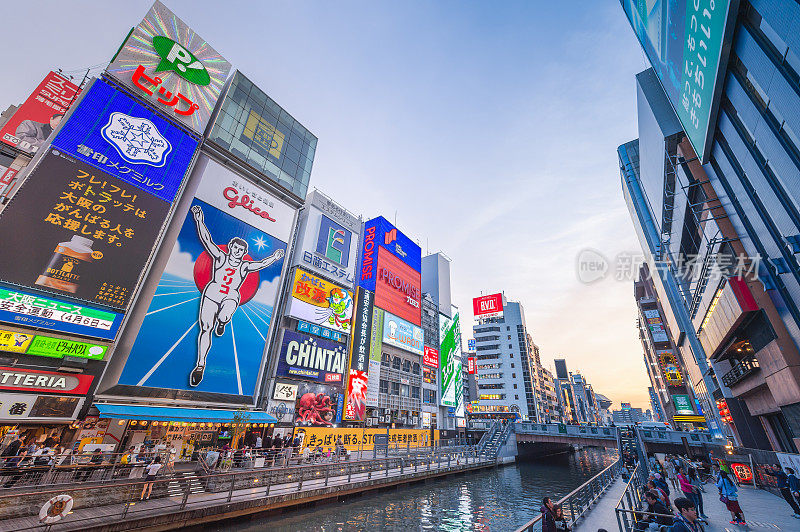 在日本大阪的道顿堀，五颜六色的广告牌照亮了大阪夜市周围的商店和零售店