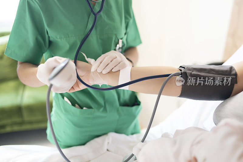一位护士在医院病房为年轻母亲测量血压